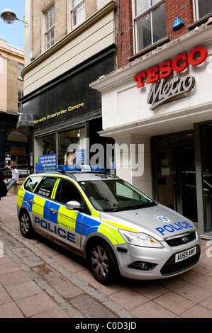 Silber Polizeiauto geparkt vor Geschäften auf einer Straße in Norwich, Norfolk, England. Stockfoto