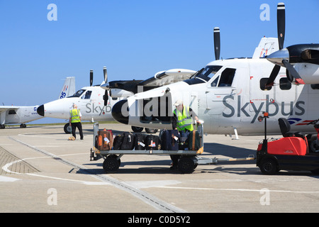 Gepäck von einem Skybus Twin Otter am St.Mary Aieport Isles of Scilly auslagern Stockfoto