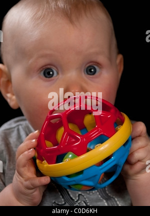 Baby Boy 8 Monate alt mit großen Augen und ein neues Spielzeug Stockfoto