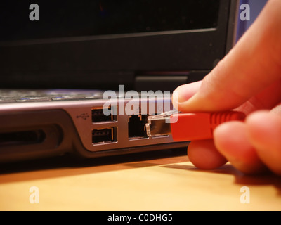 Ethernet-Verbindung an einen Laptop-Computer mit Fokus auf Port angeschlossen wird Stockfoto