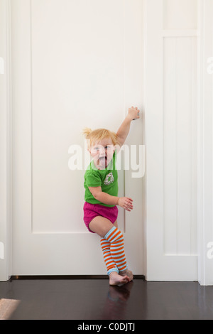 Kleines Mädchen, die versuchen, in verschlossenen Tür Stockfoto