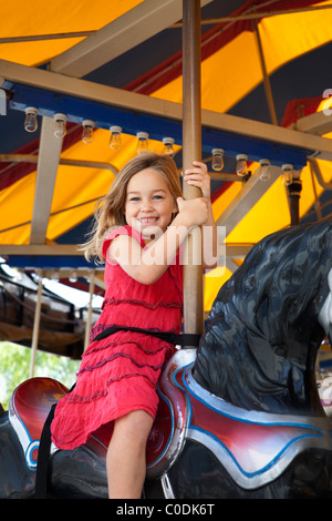 Kleines Mädchen reiten auf dem Karussell Stockfoto