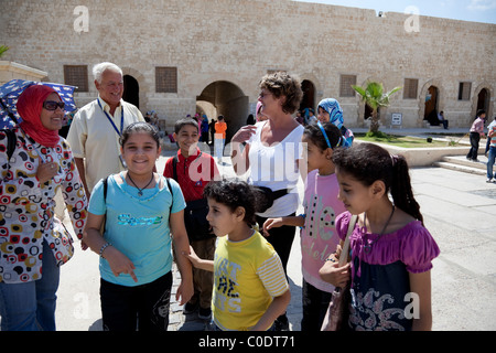 Ägyptische Kinder und Europäische Touristen glücklich treffen zusammen in der touristischen Website Qaitbay Zitadelle. Stockfoto