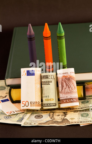 Globale Hauptgewicht auf Ausbildung in Buntstifte, Bücher, und mehrere Währungen, Dollar, Euro und Yuan symbolisiert. Stockfoto