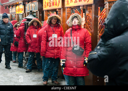 Snack-Hersteller warten im eisigen Bedingungen für Kunden in Wang Fu Jing Lebensmittelmarkt, Peking, China Stockfoto