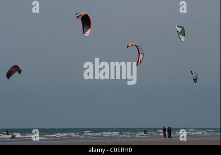 Kite Surfer mit ihren hellen Kites skimming die Wellen an Westward Ho! Devon, UK. Stockfoto