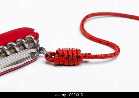 Alte Schweizer Offiziersmesser, an einer Schnur mit einem Halbblut-Knoten befestigt Stockfoto