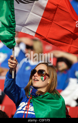 Junge Frau, die Unterstützung von Italien Wellen entsprechen einer italienischen Flagge vor einem 2010 FIFA World Cup Gruppe F zwischen Italien und der Slowakei. Stockfoto