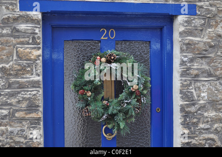 Blaue Tür mit Adventskranz Stockfoto