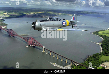 T6 "Texan", bekannt in Großbritannien als die "Harvard" ww2 Kämpfer fliegen über die vierte Schiene Brücke Stockfoto