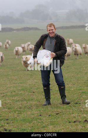 Adam Henson, Cotswolds Landwirt Fütterung seine Schafe auf Adam. BBC Countryfile TV-Moderator mit seinen Schafen. Stockfoto