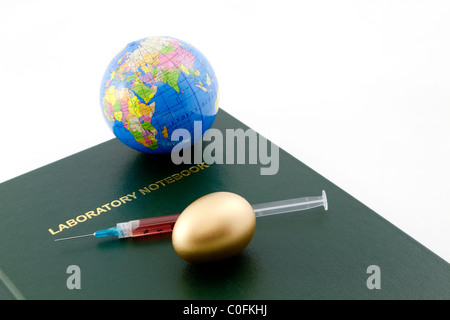 Grünes Labor Notebook mit Globe, gefüllte Spritze und goldenen Notgroschen. Stockfoto