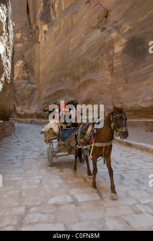 Eine Pferdekutsche galoppiert durch die schmale Siq-Schlucht hinein Die alte nabatäische Stadt Petra Jordan Stockfoto