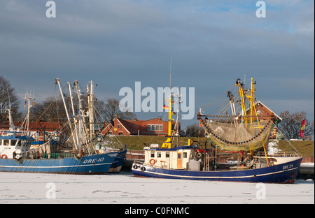 Garnelen-Kutter im Hafen von Greetsiel, Nordsee, im Hintergrund der Deich winterview Stockfoto