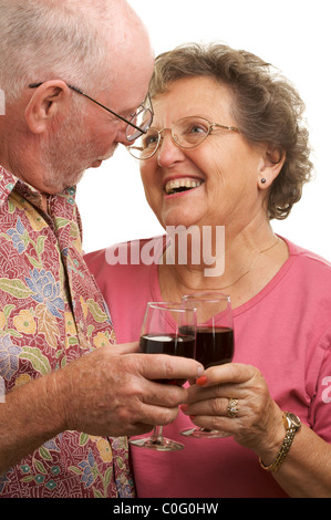 Glücklich, Lächeln älteres Paar einander zugewandt und Toasten mit Weingläsern auf weißem Hintergrund. Stockfoto