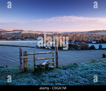 Einen Stil auf einem öffentlichen Wanderweg mit Blick auf das Dorf von Sherrington in Wiltshire an einem frostigen Herbstmorgen. Stockfoto