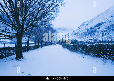 Straße nähert sich Seathwaite Farm im Morgengrauen. Winter. Lake District National Park. Cumbria. England. VEREINIGTES KÖNIGREICH. Stockfoto