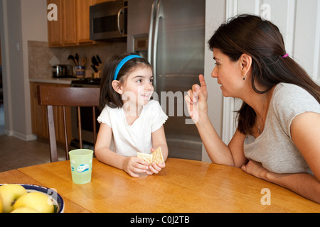 Hispanische Mutter macht einen Punkt ihrer fünf-jährigen Tochter am Frühstückstisch Zimmer in ihrem Haus in Austin Texas Stockfoto