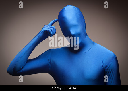 Mann trägt volle blau Nylon Body kratzte sich am Kopf auf einem grauen Hintergrund. Stockfoto