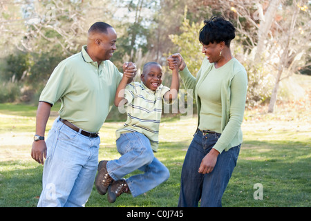 Spielerische afroamerikanische Mann, Frau und Kind Spaß im Park. Stockfoto