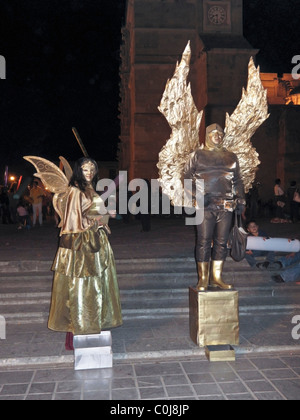 Mann & Frau schön schimmernden goldenen Engel MIME-Wahrsager hält Tasche & Box Schicksale in der Nacht Oaxaca Zocalo Stockfoto