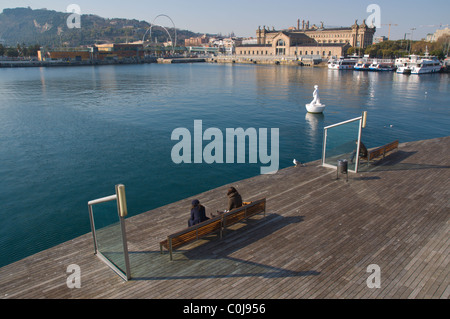 Menschen sitzen auf Bänken im Rambla del Mar Fußweg auf Port Vell Barcelona Catalunya Spanien Mitteleuropa Stockfoto