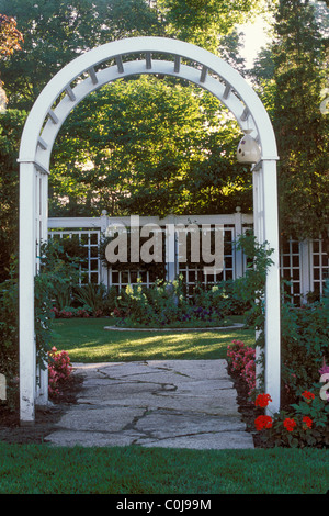 WEIßE HOLZ ARBOR FRAMES STEIN WEG IN MINNESOTA GARTEN.  BEGONIEN UND KATZENMINZE NEPETA GRENZE WEG. Stockfoto