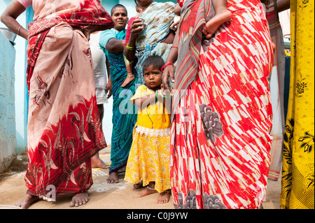 Kleine indische Mädchen stehen in zwischen indischen Frauen in einem indischen Dorf. Andhra Pradesh, Indien Stockfoto