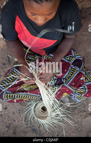 Eine erfahrene Frau spinnt einen Hut aus Stroh in Rufiji Bezirk, Tansania, Ostafrika. Stockfoto