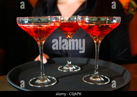 Eine Kellnerin hielt ein Tablett mit Rosa Champagner Gläser in einer bar Stockfoto