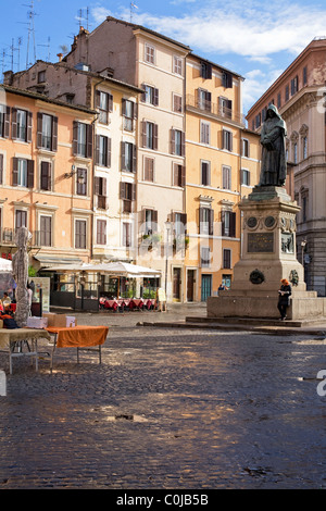 Frau liest eine Zeitung am Fuße der Statue von Giordano Bruno in Campo dei Fiori in Rom, Italien Stockfoto