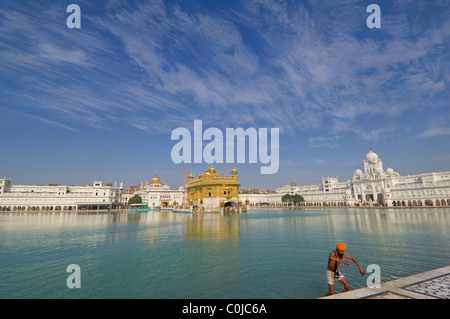 Sikh-Pilger Baden im Sarovar (Heilige Pool der unsterblichen Nektar) mit Hari Mandir (göttlichen Tempel) hinter goldenen Tempel in Amritsar, Punjab, Indien Stockfoto