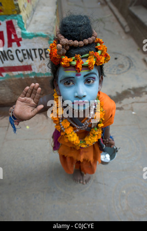 Kleiner Junge gekleidet als Shiva betteln in den Gassen der alten Stadt von Varanasi, Uttar Pradesh, Indien Stockfoto