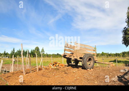 Schöne Aussicht von kleinen Wagen mit Gummireifen stehen auf einer Fläche von Braun Holzspänen Protokolle, in der Nähe von Ancud, Chiloé Insel, Chile Stockfoto