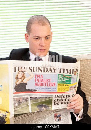 Mann liest Zeitung The Sunday Times in Großbritannien Stockfoto