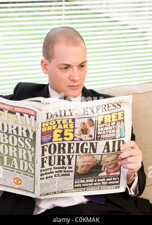 Mann liest Zeitung Daily Express in Großbritannien Stockfoto