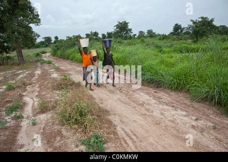 Mädchen bringen Sie nach Hause Wasser aus einem Brunnen in Safo, Mali, Westafrika. Stockfoto