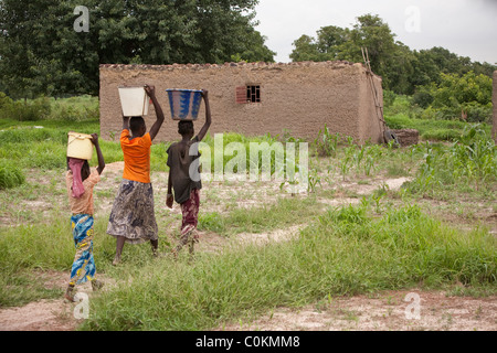 Mädchen bringen Sie nach Hause Wasser aus einem Brunnen in Safo, Mali, Westafrika. Stockfoto