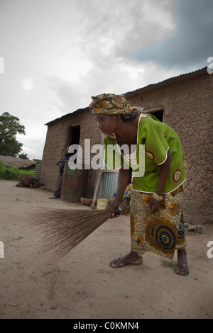 Eine junge Frau fegt die Familie Verbindung in ihrem Haus in Safo, Mali, Westafrika. Stockfoto