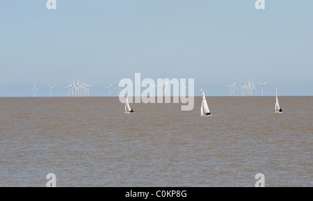 Segelboote mit Windkraftanlagen in der Ferne, Lowestoft, Suffolk, UK Stockfoto