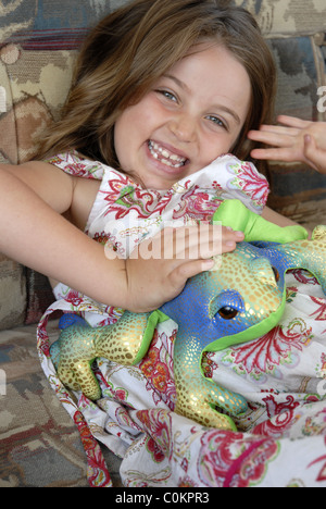 Kleines Mädchen Lachen und halten einen Spielzeug Frosch Stockfoto