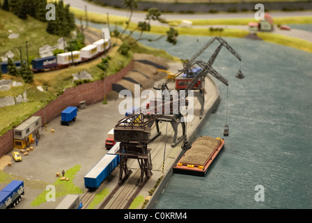 Detail des Modell Spielzeug Eisenbahn Bahnwerk mit Lok, Wagen, Gleise und Gebäude Stockfoto