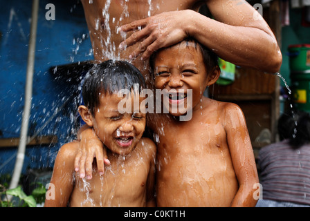 Jungen waschen auf der Straße in Malate, in Malate, Adriatico Street, Manila, Philippinen. Stockfoto