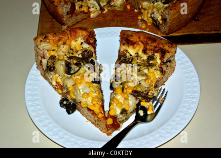 zwei Scheiben hausgemachten tiefen Teller dicke Kruste gebacken vegetarische Pizza auf weißem Porzellanteller Stockfoto