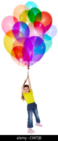 Das kleine Mädchen ist auf einem Haufen Farbe Luftballons fliegen. Stockfoto