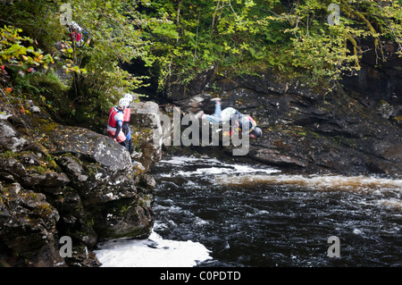 Schlucht wandern, auch bekannt als Canyoning am Wasserfall Falloch direkt an der A82 ein paar Meilen südlich von Crianlarich, Schottland Stockfoto