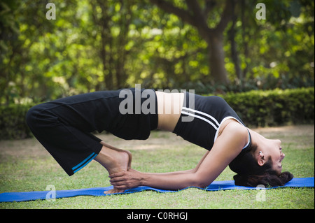 Frau Kandharasana (Schulter darstellen) zu tun Stockfoto