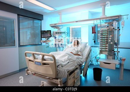 Intensivstation in einem Krankenhaus. Ein Patient wird mit verschiedenen lebenserhaltenden Systemen verbunden. Stockfoto