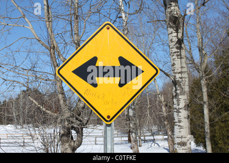 Straßenschild mit doppelten schwarzen Pfeile in entgegengesetzter Richtung Stockfoto