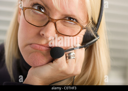 Miserable Geschäftsfrau Gespräche über ihr Handy Kopfhörer. Stockfoto